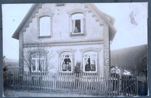 Siedlungshaus am Buchenbrink in Gerzen mit aus dem Fenster schauenden Bewohnerinnen und Bewohnern - historische Aufnahme Anfang des 20ten Jahrhunderts © privat
