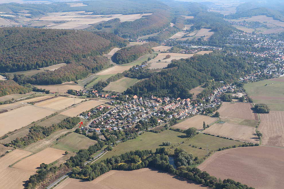 Blick auf Eimsen, ein freier Bauplatz (siehe Pfeil) mitten im Grünen. © Quintel & Schütz 2018__Eimsen_Luftaufnahme_Pfeil